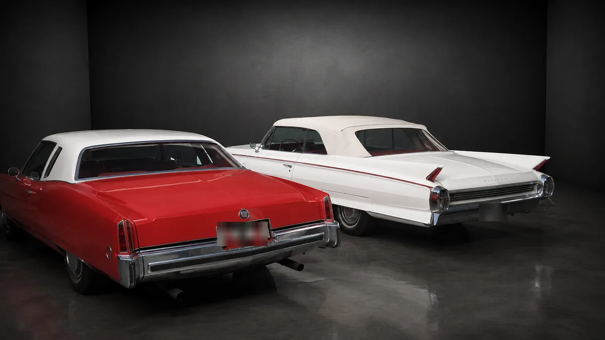 Dieselben zwei Cadillac von hinten, links das rote Coupé, rechts das weiße Cabrio mit aufgestellten Heckflossen